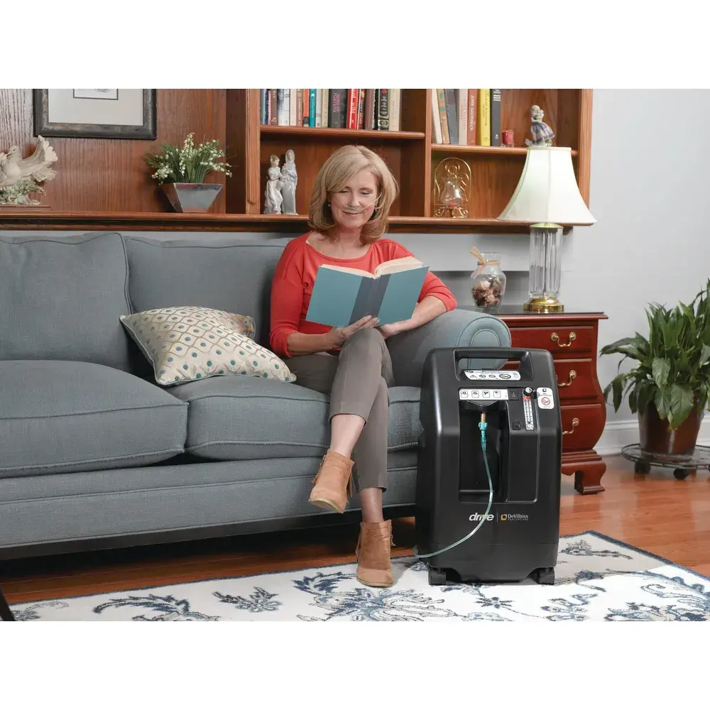 women on a couch using an oxygen concentrator in a living room